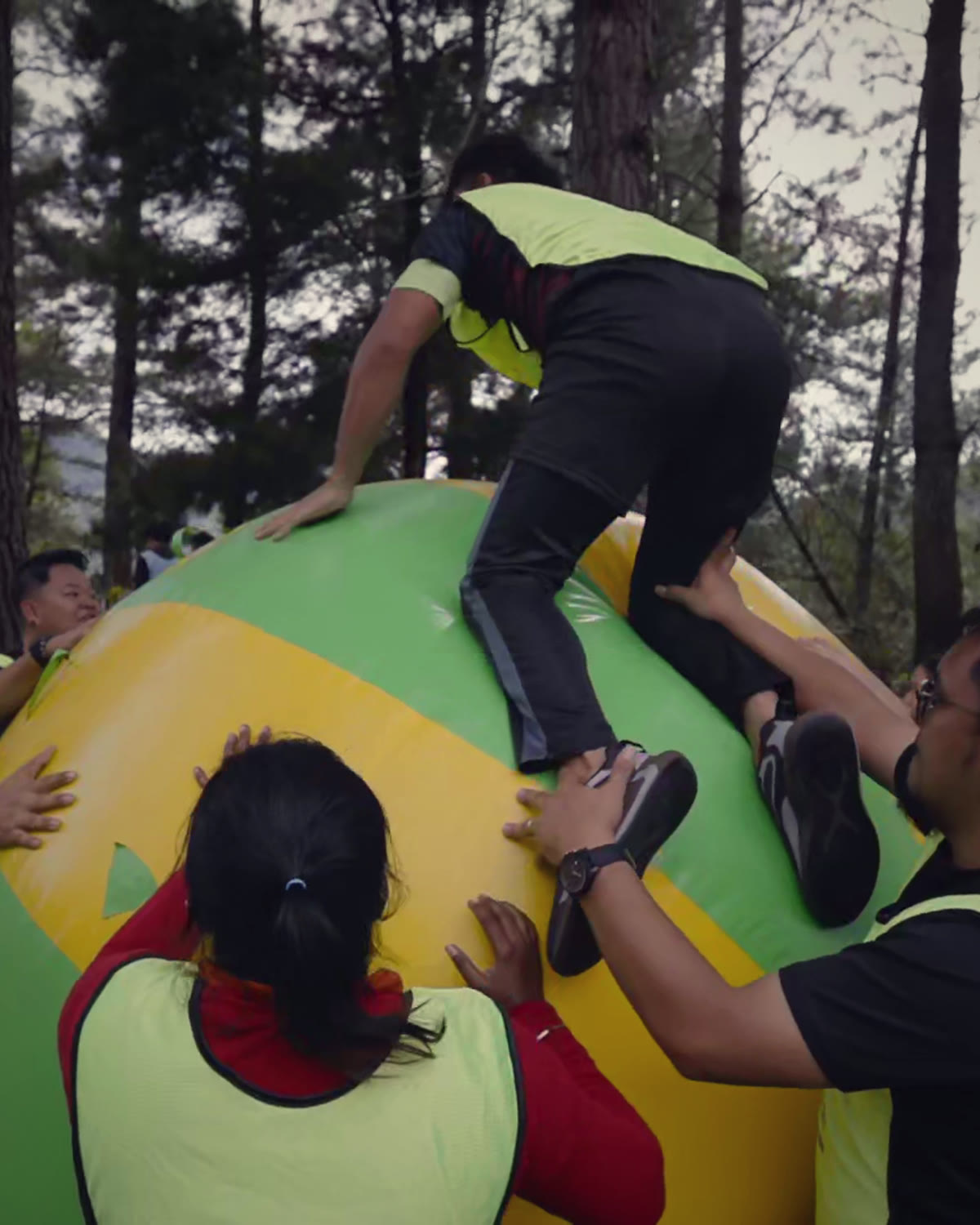 SLT Academy team boosting a colleague up onto a giant ball during a team-building challenge